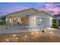 Charming home with a well-lit front yard, screened porch and a white picket fence at 2805 Burgos Dr, The Villages, FL 32162