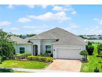 Charming single-story home featuring a brick driveway and manicured landscaping at 313 Blue Cypress Dr, Groveland, FL 34736