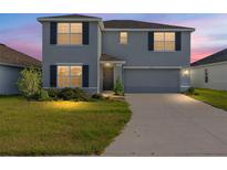 Charming two-story home features a well-maintained lawn, gray exterior, and attached two-car garage at 4713 Sw 86 Ln, Ocala, FL 34476