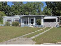 Charming single-story home featuring a well-maintained lawn, covered porch, and a welcoming facade at 504 Se 35Th Ave, Ocala, FL 34471
