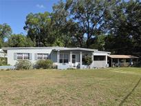 Charming single-story home featuring a quaint front porch and a well-manicured lawn under a sunny sky at 504 Se 35Th Ave, Ocala, FL 34471