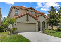 Charming two-story home features a well-manicured lawn, tile roof, and a two-car garage at 5241 Oakbourne Ave, Davenport, FL 33837