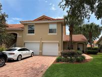 Charming townhome with a two-car garage, red tile roof, and well-maintained landscaping in a sunny setting at 5437 Compass Pt # 00, Oxford, FL 34484