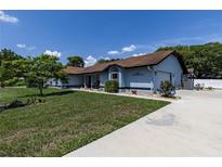 Charming single-story home with a well-maintained lawn, blue exterior and a spacious driveway at 5521 Oak St, Mount Dora, FL 32757