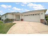 Charming single-story home features an attached two-car garage and a well-manicured front yard at 8639 Se 141St Pl, Summerfield, FL 34491