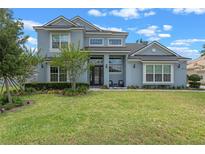 Beautiful two-story home featuring a lush green lawn and attractive landscaping that adds great curb appeal at 9512 Mid Summer Ln, Leesburg, FL 34788
