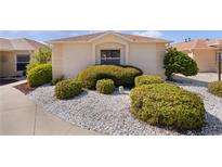 Well-manicured front yard with white rock and mature shrubbery near the façade of the home at 1116 San Bernardo Rd, The Villages, FL 32162