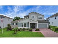 Stunning two-story home featuring a brick driveway, a two-car garage, and a beautifully landscaped yard at 14501 Wabasso Loop, Winter Garden, FL 34787