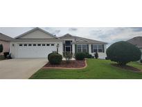 Charming home featuring manicured landscaping and a welcoming two-car garage at 1550 Ward Ct, The Villages, FL 32162