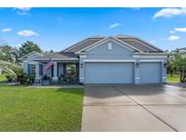 Charming one-story home with a well-manicured lawn, two-car garage, and inviting front porch at 1640 Marsh Pointe Dr, Clermont, FL 34711