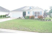 Charming home featuring a well-manicured lawn and colorful landscaping at 1676 Van Buren Way, The Villages, FL 32162