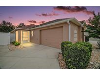 Charming single-story home with a two-car garage, lush landscaping, and a screened-in porch at 16827 Se 92Nd Lance Ct, The Villages, FL 32162
