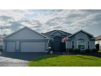 Charming single-story home with a well-manicured lawn and attached two-car garage at 1706 Augustine Dr, The Villages, FL 32159