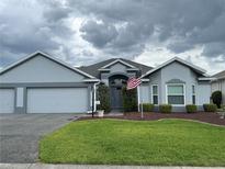 Charming single-story home featuring a well-manicured lawn and an attached two-car garage at 1706 Augustine Dr, The Villages, FL 32159