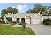 Charming single-story home with well-manicured lawn, two-car garage, and inviting entrance at 215 Chula Vista Ave, The Villages, FL 32159