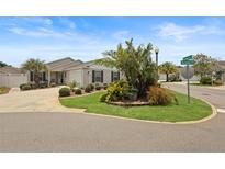Charming single-story home featuring a well-manicured lawn and lush landscaping at 2312 Nackman Pl, The Villages, FL 32162