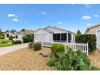 Charming home featuring a white picket fence, well-kept landscaping, and a welcoming exterior at 2317 Whisper St, The Villages, FL 32162