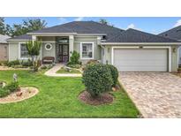 Inviting home features a manicured lawn, walkway and two car garage at 25222 Laurel Valley Rd, Leesburg, FL 34748