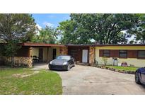 Single-story home with stone accents and a long driveway at 2707 Woodbridge Ln, Orlando, FL 32808