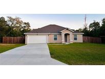 Charming one-story home with a spacious front yard, long driveway, and a two-car garage at 4002 Sw 158Th Street Rd, Ocala, FL 34473