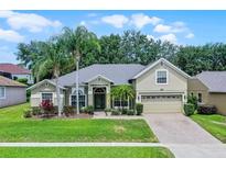 Charming single-story home featuring lush landscaping, mature palm trees, and a welcoming two-car garage at 4239 Fawn Meadows Cir, Clermont, FL 34711