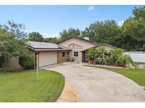 Charming single-story home featuring a two-car garage, front yard landscaping and solar panels at 721 Mendoza Dr, Orlando, FL 32825