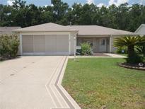 Charming single-story home boasts a well-manicured lawn and decorative driveway, enhancing its curb appeal at 8377 Se 177Th Bartram Loop, The Villages, FL 32162