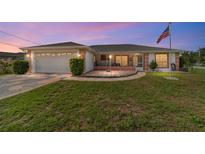 Charming single-story home featuring a well-manicured lawn, a two-car garage, and a welcoming screened-in porch at 8850 Se 156Th St, Summerfield, FL 34491
