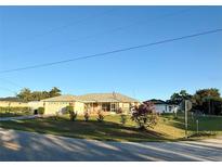 Charming one-story home featuring a well-manicured lawn, attached garage, and a cozy screened-in porch at 8850 Se 156Th St, Summerfield, FL 34491