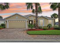 Charming single-story home with a brick driveway, well-manicured landscaping, and a two-car garage at 10046 Ketch Kay Ln, Oxford, FL 34484