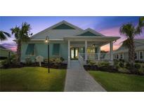 Charming coastal-style home featuring a welcoming front porch, lush landscaping, and a well-manicured lawn at 1057 Sugarloaf Key Loop, Lady Lake, FL 32159