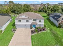 Beautiful two-story home with well-manicured lawn and a three car garage and a bright blue front door at 1824 Forest Glen Dr, Fruitland Park, FL 34731
