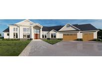 Stunning two-story home with large windows, a three-car garage, and a professionally landscaped yard at 2421 Shady Ln, Groveland, FL 34736