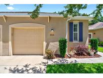 Inviting home exterior with garage, manicured lawn, and charming window shutters at 27121 White Plains Way, Leesburg, FL 34748