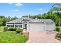Charming single-story home featuring well-manicured landscaping and a three-car garage at 2991 Saint Thomas Ln, The Villages, FL 32162