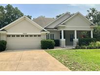 Charming single-story home with a two-car garage, well-maintained lawn, and inviting front porch at 30604 Apawamis Dr, Sorrento, FL 32776