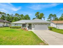 Charming single-story home with well-maintained lawn and attached two-car garage at 39 Pine Court Dr, Ocala, FL 34472