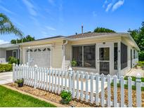 Charming home with a white picket fence, attached garage, and screened-in porch at 8195 Se 174Th Rowland St, The Villages, FL 32162