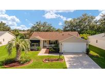 Charming single-story home with a well-manicured lawn, mature trees, and inviting curb appeal at 8537 Se 177Th Bartram Loop, The Villages, FL 32162