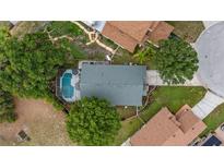 An aerial view showcases the backyard pool and peaceful neighborhood at 1130 Woodsong Way, Clermont, FL 34714