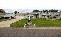 Charming single-story home featuring well-manicured lawn and flowerbeds, plus an attached two-car garage at 17533 Se 96Th Ct, Summerfield, FL 34491
