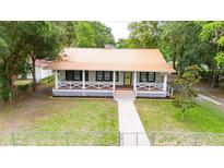 Charming home featuring a metal roof, inviting front porch, and well-maintained lawn at 263 Ne 1St St, Webster, FL 33597