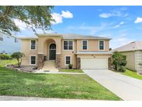 Charming two-story home featuring stone accents, a manicured lawn, and a welcoming two-car garage at 2745 Shearwater St, Clermont, FL 34711