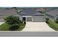 Beautiful single-story home with manicured landscaping and a spacious driveway at 6301 Danielson Loop, The Villages, FL 32163