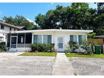 Cozy single-story home with a screened-in porch, tidy landscaping, and a well-maintained walkway at 679 Avenue Q Se, Winter Haven, FL 33880