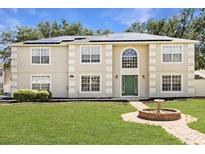 Charming two-story home featuring a well-maintained lawn, green door, and solar panels at 800 Daybreak Dr, Fruitland Park, FL 34731