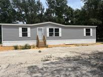 Charming single-story home featuring gray siding, white trim, and well-maintained landscaping at 892 Se 124Th Ave, Webster, FL 33597