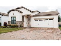 Charming single-Gathering home featuring a two-car garage and a brick-paved driveway at 9219 Chandler Dr, Groveland, FL 34736