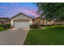 Charming single-story home with a well-manicured lawn and beautiful landscaping at 9588 Se 124Th Loop, Summerfield, FL 34491