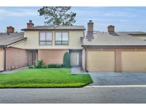 Charming townhome featuring a well-manicured lawn, brick facade, and attached garages on a sunny day at 102 Lake Emma Cove Dr # 102, Lake Mary, FL 32746